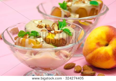 Baked Peaches Dessert In An Ice-cream Bowl Topped Sabayon Cream With Almond And Mint Against The Pin
