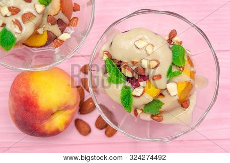Baked Peaches Dessert In An Ice-cream Bowl Topped Sabayon Cream With Almond And Mint Against The Pin