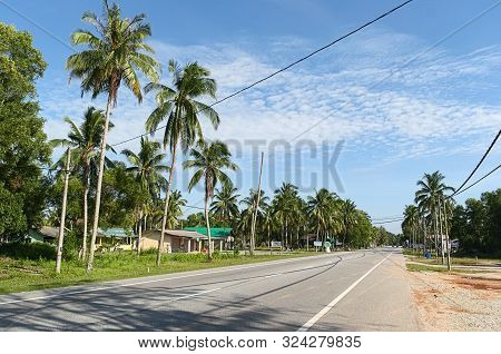 Kampung Merang, Malaysia - July, 2015: Road In A Small Village Near The Sea Along Palm Trees.
