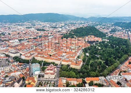 Aerial View Of Center City Graz From Helicopter Drone With Hill Schloßberg, Tower Uhrturm And Centra