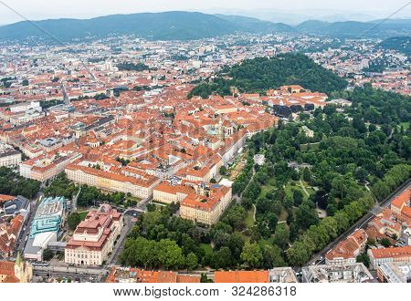 Aerial View Of Center City Graz From Helicopter Drone With Hill Schloßberg, Tower Uhrturm And Centra