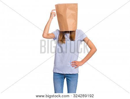 Pensive teen girl with paper bag over head. Thoughtful teenager cover head with bag holding hand near face isolated on white background. Child pulling paper bag over head.