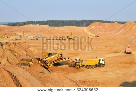 Wheel Front-end Loader Unloading Sand Into Heavy Dump Truck. Crushing Plants, Machines And Equipment