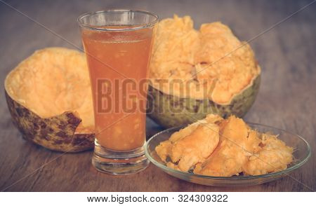 Medicinal Bael Fruit With Juice In A Glass On Wooden Surface