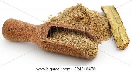 Liquorice With Powder In Scoop Over White Background