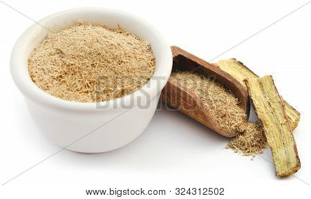 Liquorice Stick And Ground In A Small Bowl Over White Background