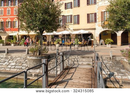 View Of Picturesque Village Morcote With Outdoor Bars And Gift Shops On The Shore Of Lake Lugano In