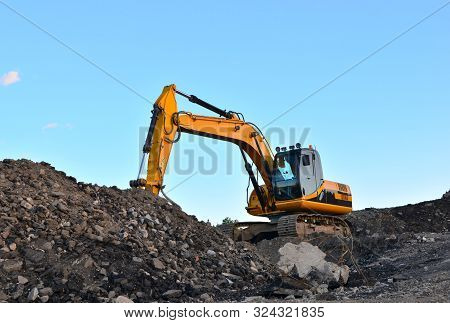Large Tracked Excavator Works In A Gravel Pit. Loading Of Stone And Rubble For Its Processing At A C