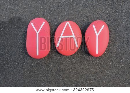 Yay Word Composed With Red Colored Stones Over Black Sand