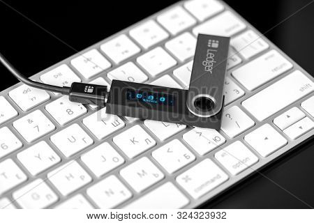 UKRAINE, ROVNO - On 26 September: Ledger hardware wallet for cryptocurrency on a wood black background