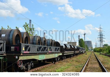 Rolled Steel Coil On On A Freight Train Fixed By A Chain. Import/export, Logistics Of The Heavy Carg
