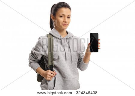 Girl in a hoodie with a bacpack showing a smartphone isolated on white background