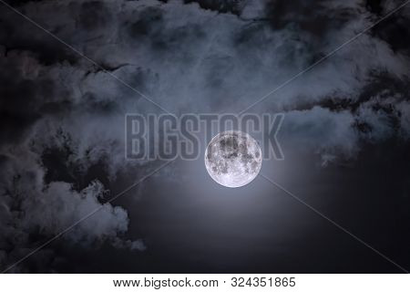 Night Sky And A Full Moon In The Clouds. Full Moon Against The Dark Night Sky.