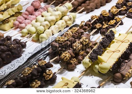Fruits Bananas, Strawberries, Nuts, Apples, Peaches Drenched In White And Dark Chocolate.