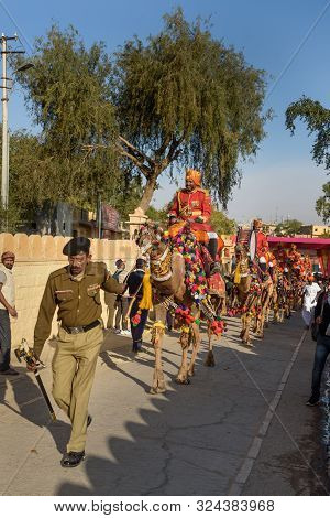 Jaisalmer, India - February 17, 2019: Ceremonial Procession Camels And Riders In Desert Festival In 