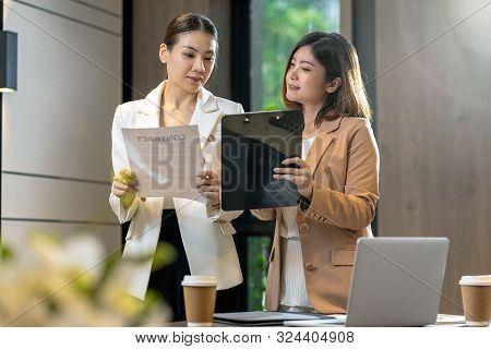 Two Asian Businesswomen Discussing With The Partner Business About Business Contract By Technology L