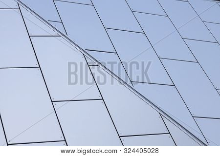 Angular View Of White Matte Tiles With Blueness Shade On Wall Of Building