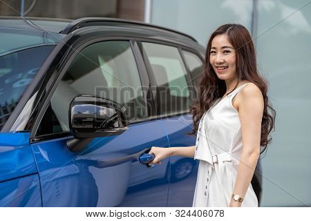 Portrat Of Asian Customer Woman Opening The Car Door When Get The New Blue Color Car Infront Of Show