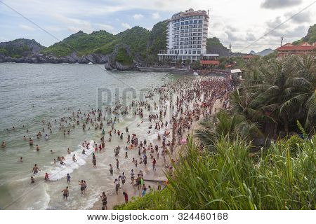 Many Chinese Tourists On The Beach Swim In The Waves
