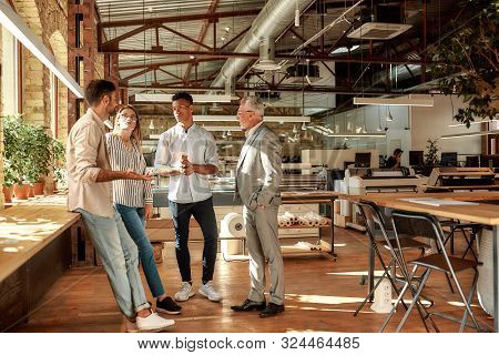 Fast Meeting. Business People Holding Coffee Cups And Talking About Something While Standing In The 