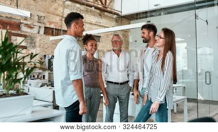 Happy And Successful. Group Of Cheerful Business People Standing In The Modern Office, Smiling And D