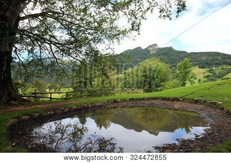 Alpine Small Pond And The Reflection Of Mountains On The Water In Summer