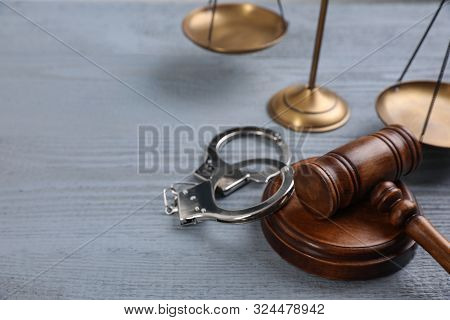 Gavel, Handcuffs And Scales Of Justice On Grey Wooden Table, Space For Text. Criminal Law