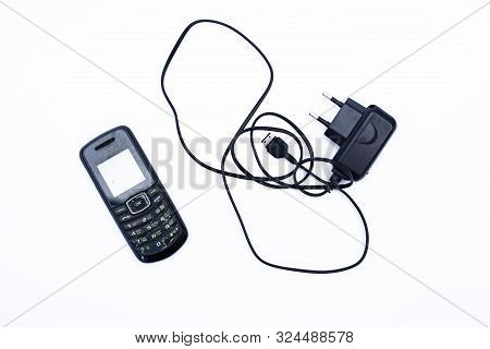 Old Cellphone And Charger On White Background