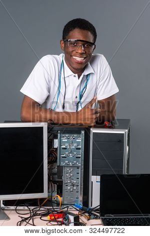 Attractive Man In Safety Glasses Leaning On Computers. Screen, Microschemes, Cords, Analogue Multime