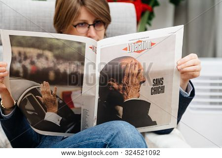 Paris, France - Sep 27, 2019: Woman Reading French Liberation In Living Room Newspaper Following The
