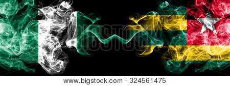 Nigeria Vs Togo, Togolese Abstract Smoky Mystic Flags Placed Side By Side. Thick Colored Silky Smoke