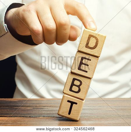 Businessman Removes Wooden Blocks With The Word Debt. Debt Relief Or Cancellation Is The Partial Or 