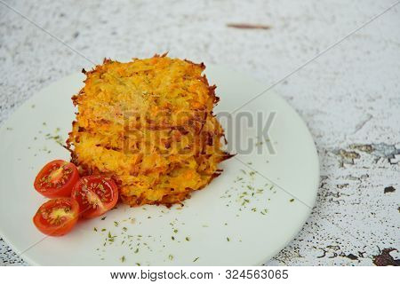 Hash Browns Or Potato Pancakes Or Swiss Rösti Garnish With Cherry Tomato And Parsley