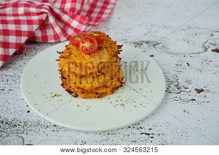 Hash Browns Or Potato Pancakes Or Swiss Rösti Garnish With Cherry Tomato And Parsley