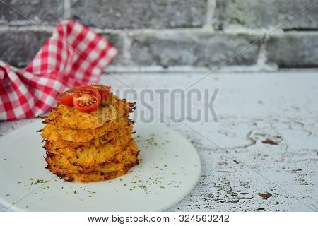 Hash Browns Or Potato Pancakes Or Swiss Rösti Garnish With Cherry Tomato And Parsley