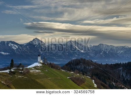 Panoramic View At St. Primus And Felician Church In Jamnik, Julian Alps, Slovenia