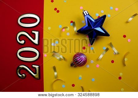 On A Red And Yellow Background Are Laid Out The Numbers 2020 With Confetti And Christmas Toys