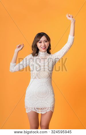 Young Pretty Asian Woman Smiling With Energetic Movement Studio Shot Isolatede On Colorful Yellow Ba