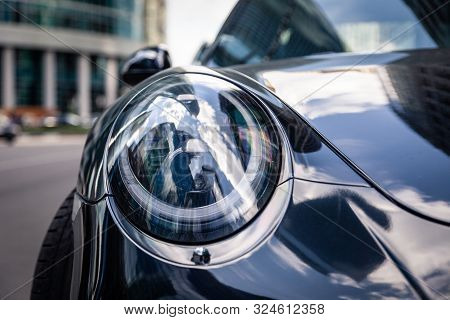 Russia Moscow 2019-06-17 Closeup Headlights Of New Shiny Luxury Dark Blue Sports Car Porsche 911 Par