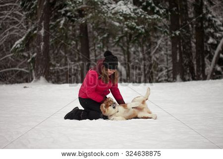 Portrait With A Cute Fluffy Puppy. Winter Walk With A Dog. Young Woman Walks With The Puppy, Snowy W