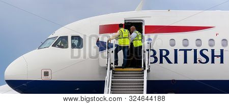 Bucharest, Romania - July 15, 2019: Ramp agents secures the ladder of British Airways G-EUXG aircraft parked in the VIP reception area of ​​Henri Coanda Airport in Otopeni, 20 km. north of Bucharest.
