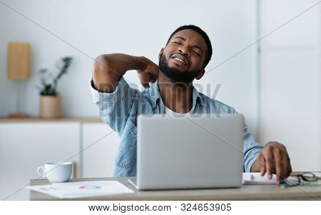 Neck Pain. Black Businessman Suffering From Acute Neckache After Long Workday In Office, Free Space