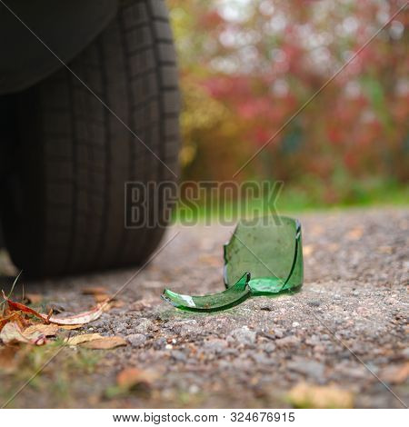Broken Bottle Glass In Front Of A Car Tire, Outdoot Shallow Depth Of Field Shot