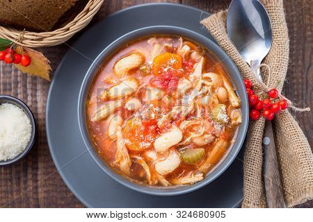 Soup With Turkey, Pasta, Carrot, Celery, Tomato And Cannellini Beans, Garnished With Parmesan Cheese
