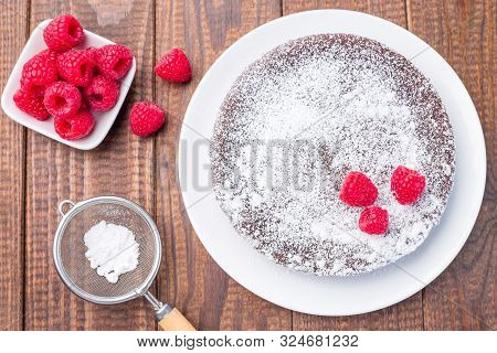 Chocolate Sticky Brownie Cake, Swedish Dessert Kladdkaka, On The Plate, Garnished With Icing Sugar A