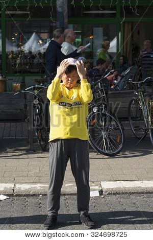 Sint Niklaas, Belgium, September 8, 2019, Oriental Woman With Hat Practiced Falun Dafa, Breathes Pow