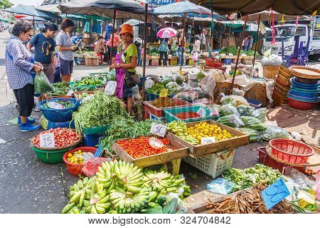 Bangkok, Thailand - January 5th 2010: Woman Selling Fruit And Vegetables On Khlong Toei Market. This