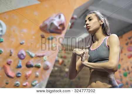 Young Attractive Athletic Woman With Muscular Naked Torso Stretching Arms Before Climb In Indoor Cli