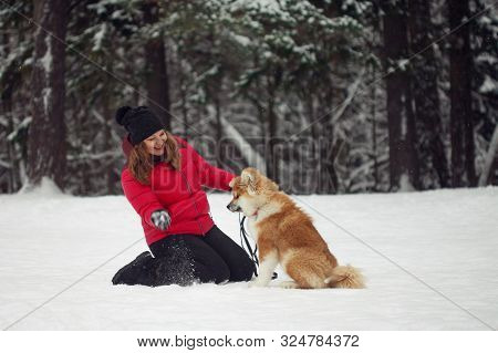 Portrait With A Cute Fluffy Puppy. Winter Walk With A Dog. Young Woman Walks With The Puppy, Snowy W