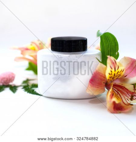 Jar With Loose Powder And Alstroemeria Flowers.